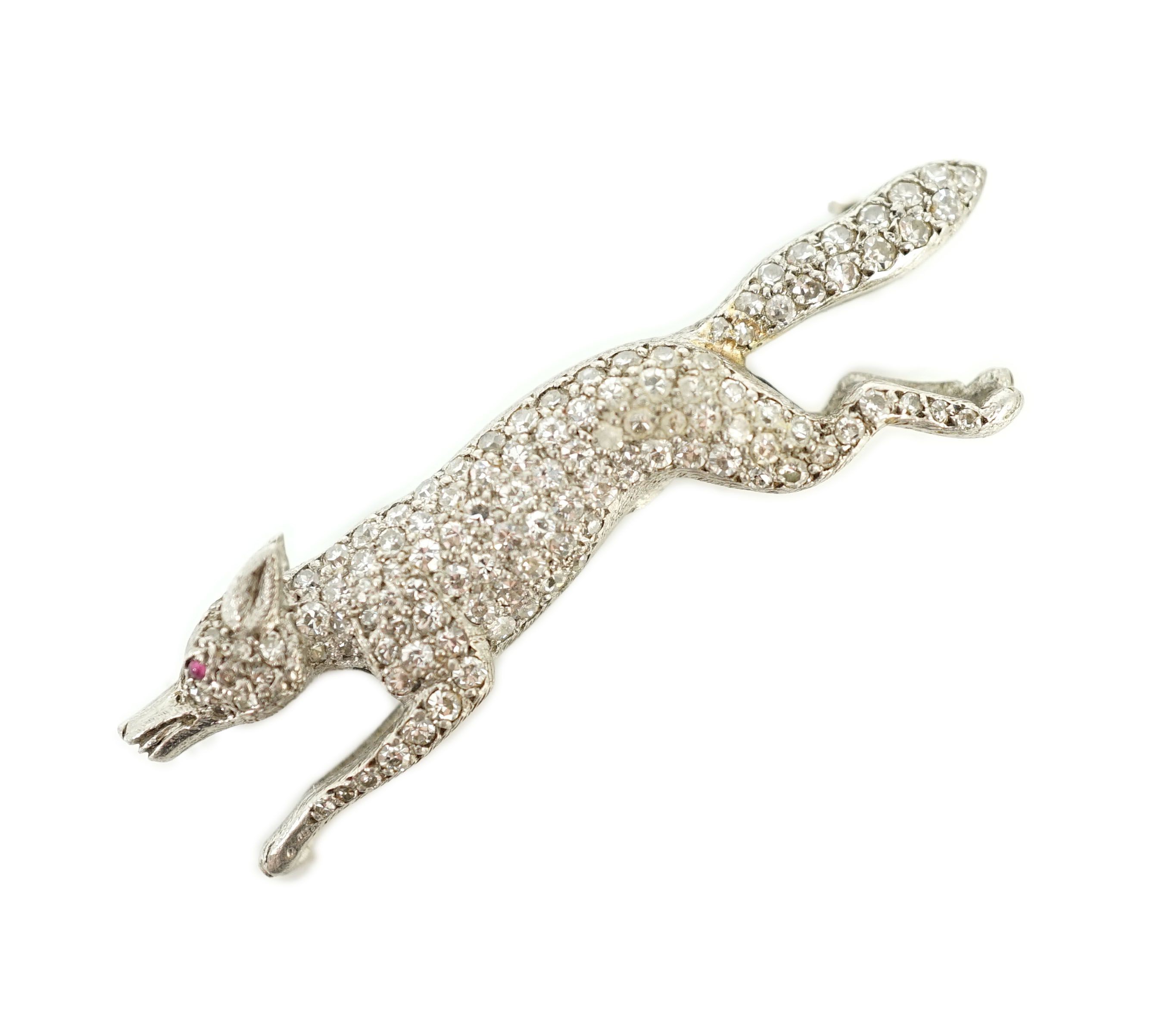 A Victorian style white gold, diamond encrusted and cabochon garnet set brooch, modelled as a running fox